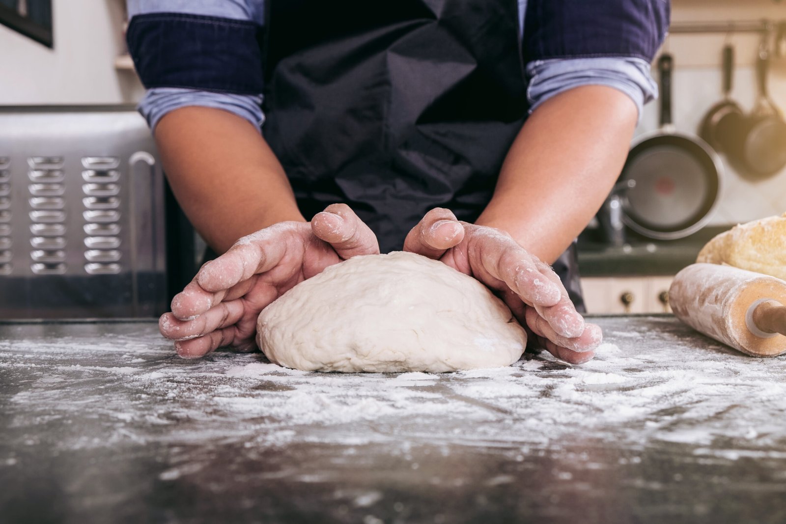 homme pétrissant de la pate à pizza